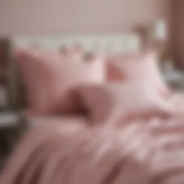 Light pink bedspread styled with decorative pillows